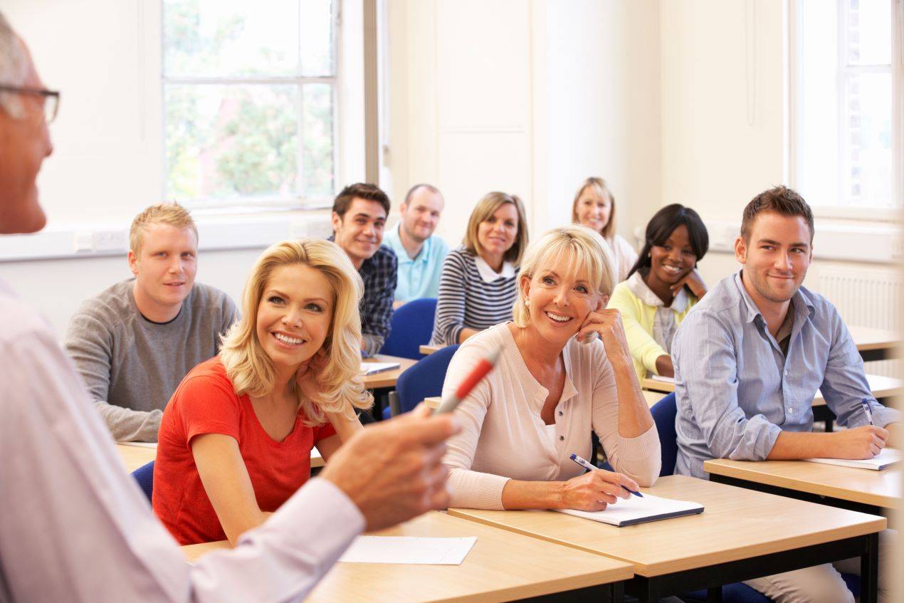 eilnehmer in einem CZV-Kurs sitzen aufmerksam in einem Klassenzimmer und hören dem Dozenten zu.